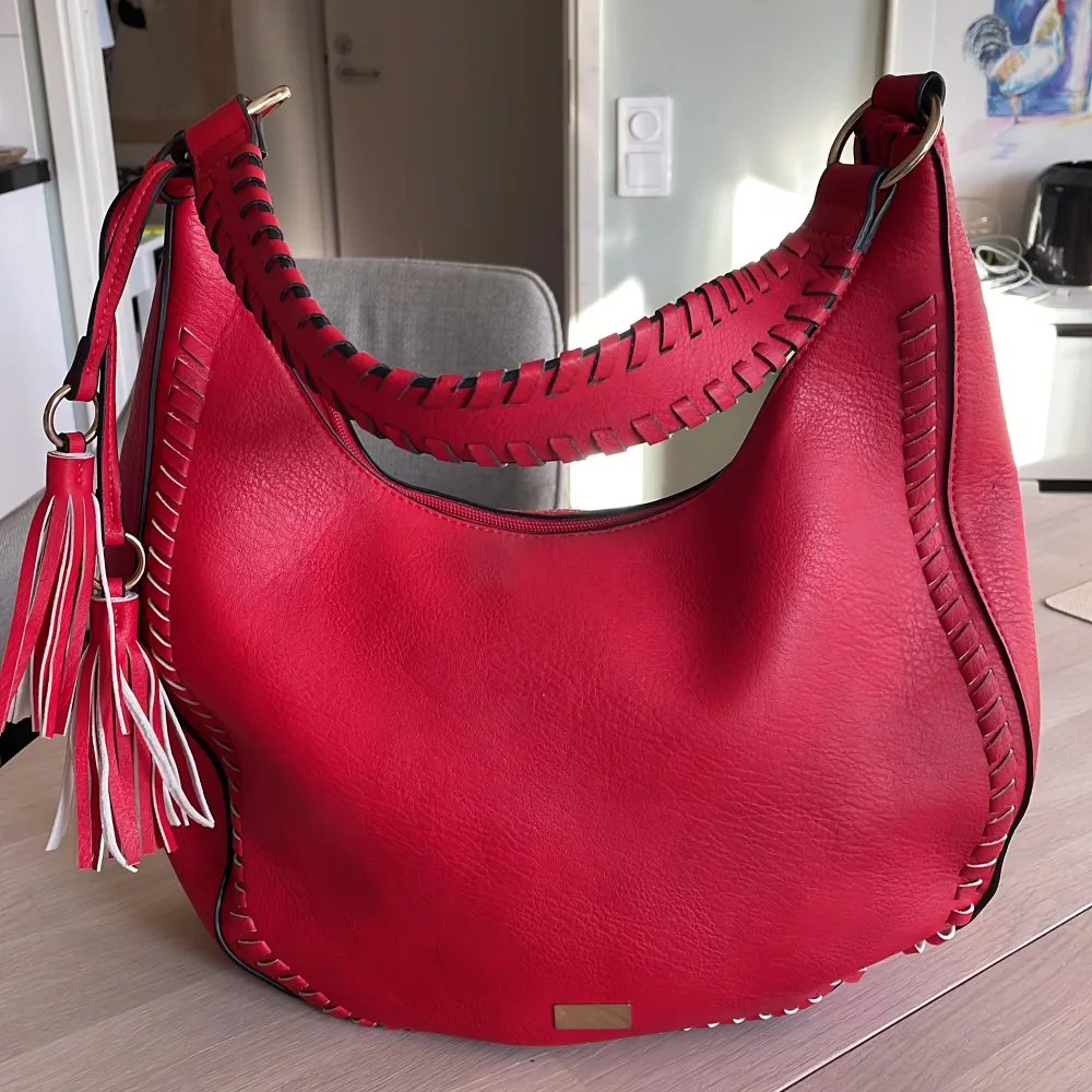 Snygg röd handväska som ny med snygga detaljer och fin form. Köpt i Spanien. Väskor.