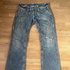 TRUE RELIGION BILLY SUPER T - True religion billy super t i väldigt bra skick med tanke på sin ålder 👵🏼👵🏼 Storlek 29 i midjan men sitter mer som 30 🔥‼️😵 Längd 32 passar mig bra som är kring 180 lång 😵‍💫😵‍💫🤙🏼 Factory distressed hella fire 😤😤🤩