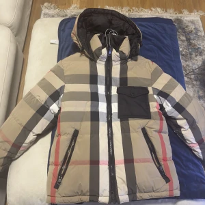 Burberry Reversible Puffer Jacket - Nypris: 18 500kr En reversibel burberry jacka, går alltså att vända ut och in. storlek M, passar även storlek L då burberry är lite större i storlekar. Små fläckar kan förekomma! Skick är 8/10! Pris kan diskuteras!