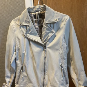 Äkta skinnjacka vintage - Äkta skinnjacka i vintage look med orm mönster i siden på insidan. Jackan är i superfint skick!