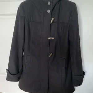 Jacka - En jacka/kappa från Lindex. Ganska rejäl och tjock med dragkedja och knäppen