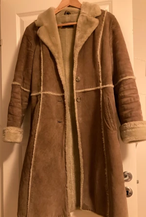 Läder rock  - Säljer denna rock gjord av äkta läder, använts fåtal gånger, saknar en knapp men säljer i befintligt skick. Knälång, person på bild: 158cm. Pris kan diskuteras.