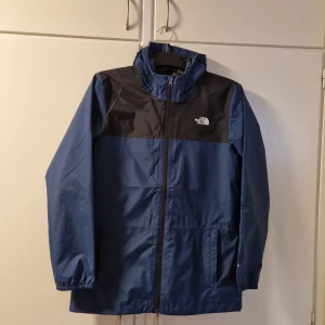 The North Face jacka - Säljer en blå The North Face  Chavano skaljacka eftersom den inte passar mig. Jackan är aldrig använd och har då såklart inga fläckar, repor eller märken. Storlek: Barn XL (vuxen XS/S) Skick: 10/10, Pris: 300 kr, Nypris: 1099kr Kan även tänka mig ett byte