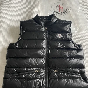 Moncler väst - Säljer en moncler väst storlek 4 passar L/M  modellen är 180 och bär vanligts M nyskick 10/10