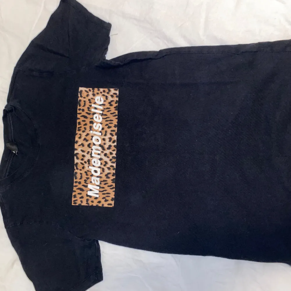 Säljer en svart T-shirt från Ginatricot. Är i storlek XS och har ett leopardmönstrat tryck. Använd flitigt. OBS: köparen står för frakten. (Annonsen finns ute på fler sidor.). T-shirts.