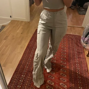 Långa cargobyxor oanvända - Säljer dessa fina cargobyxor  från Prettylittlething, köptes i våras men har aldrig använts därav etiketterna som är kvar. Storlek 38 och i TALL. Jag är 175 och dem passar bra i längden ( Passar även 180+ ). Säljer då dem är lite för stora i midjan på mig