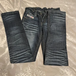 Lågmidjade jeans - Raka lågmidjade jeans med justerbar midja och dekorationer.  Inga defekter! innerbenslängd: 80cm