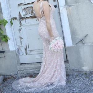 Nude/puderrosa festklänning - Vacker festklänning fylld med diamanter och pärlor. I väldigt gott skick, använd enstaka timmar endast. Insydd bh.