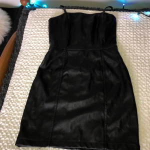 Fake skinn klänning från H:M - Tight klänning i skinn som framhäver ens former ifall man gillar det, oanvänd och i nyskick.