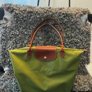 Longchamp väska - Intresseskoll på min longchampväska. Fint skick överlag, dock sliten i två hörn som syns på sista bilden. Dock inget jag märkt fram tills nu när jag tog bilderna. Köpt för några år sedan för 1,500kr. Tänker lägst 600kr men priset kan öka/minska.