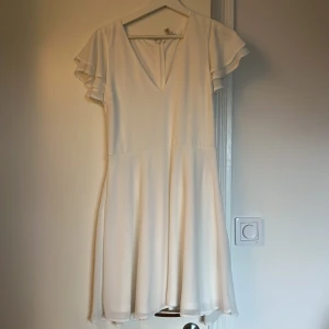 Studentklänning  - Vit studentklänning, endast använd på studenten. Skärp saknas, jag använde utan skärp 