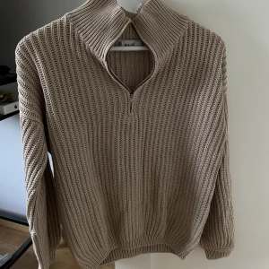 Oversized stickad tröja med dragkedja  - Oversized beige tröja från nakd med en zip i kragen. Använd ganska mycket så säljer billigt. Dock fortfarande i bra skick och inga defekter. 