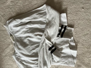 Vit tröja - En vit tröja med svarta ränder längst ner på armarna