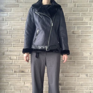 Svart bickerjacka/vinterjacka - Vinterjacka med fuskpäls material på insidan.  OBS det är två defekter, en flärp som man hänger upp jackan med och en flärp till skärpet har gått av. Om bilder önskas så skickar jag det till dig 💕 Jag är 172cm, se bilder för passform