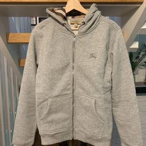 Burberry zip up grå - Grå Burberry zip up hoodie i storlek M. Har använts fåtal gånger och är nästan som ny. Hör av er vid fler frågor☺️