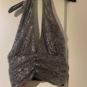 Topp - Glitter topp med öppen rygg. Insydda knappar men går att ändra om man vill. Fint skick  Storlek L