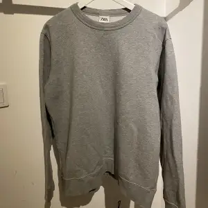 Säljer en grå sweatshirt från Zara i storlek XL. Passformen är liten så skulle säga det är en L. 100% bomull men ganska tunn! Inga synliga skador på den då den är sparsamt använd! Skriv för mer info eller vid funderingar🤙🏼