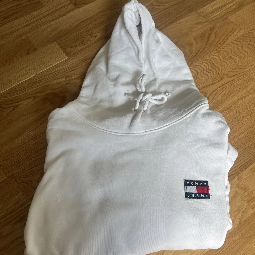 Vit hoodie ifrån Tommy Jeans i storlek XL. Upplever den lite oversize men passar mig som har L. Jättefint skick och är använd max 5 gånger. . Hoodies.