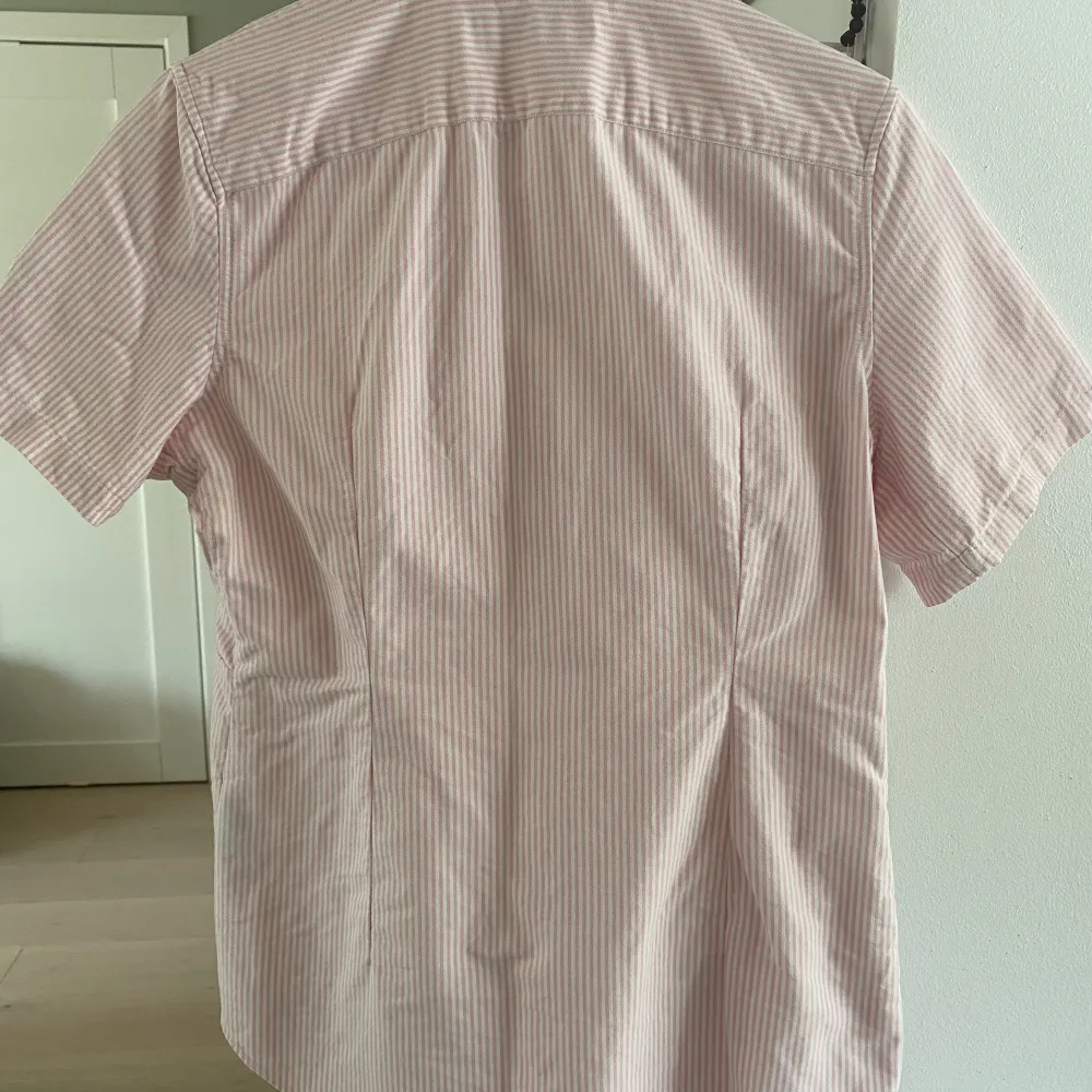 Rosa-vit randig kortärmad skjorta i storlek M från Polo Ralph Lauren. Skjortan har inga fläckar eller tecken på slitage. Säljer pga att jag inte använt skjortan på väldigt länge.. Skjortor.