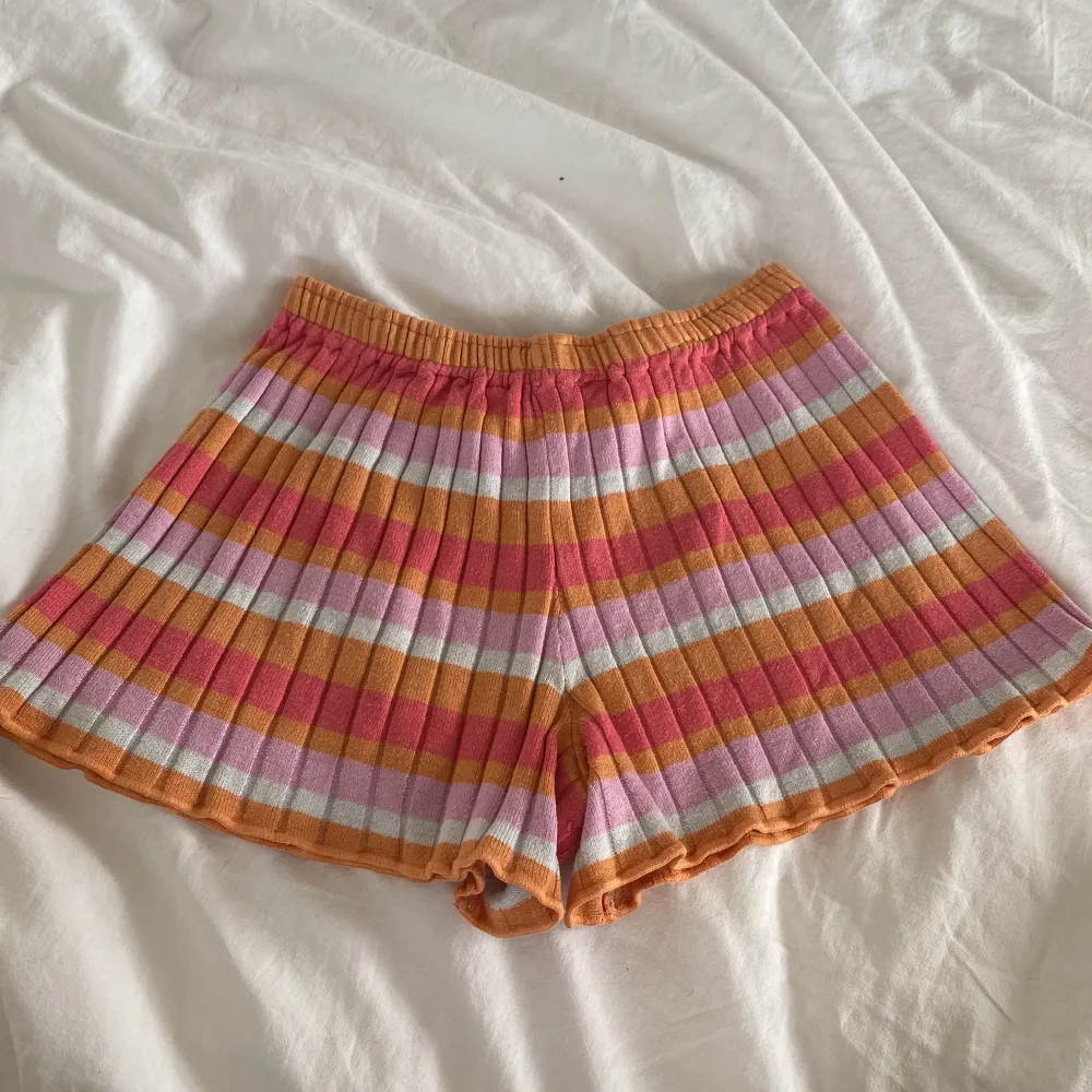 Midrise randiga mjukisshorts i färgerna rosa, orange och vit.🤍💕🧡 Är i barnstorleken 122-128 men passar xs-s då dom är stretchiga💓bra skick, frakten tillkommer💌. Shorts.