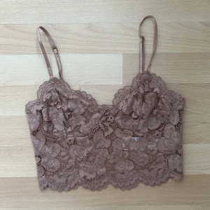 Fest topp i spets  - Kort spetstopp i smuts-rosa, perfekt till fest. Använt skick. 