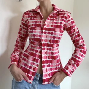 Unik rosa vintage skjorta - Vintage skjorta med unikt rosa och rött mönster samt större krage i storlek M.  Påminner mig om barbiekläder! 🤭