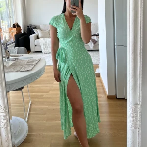 & other stories omlott klänning grön 34 - Klänning från other stories i storlek 34/XS, använd ett fåtal gånger och i mycket fint skick, som ny. Jag är 160 som referens och har storlek XS i kläder. Köparen står för frakt som tillkommer på 74 kr spårbart med postnord. 