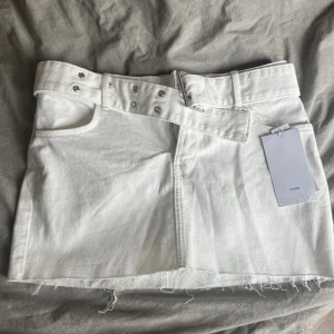 Vit jeanskjol från Bershka - Snygg jeanskjol från bershka. Köpt på asos förra året. Beställde en i storlek 36 och en i 34 men tyvärr passade ingen av dem. Därför säljer jag en i storlek 34 och en i 36. Kjolen är lowwaist och har ett spänne som en snygg detalj. 