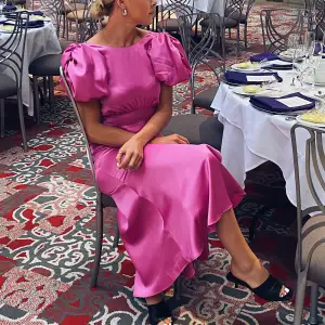 Superfin rosa satin klänning med puffärm. Endast använd på ett bröllop i USA. Kemtvättad efter💗