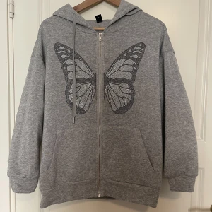 Hoodie med rhinestones tryck - En grå zip up hoodie köpt från SHEIN. Använd cirka 5 gånger och har inga defekter. Alla rhinestones sitter kvar. 