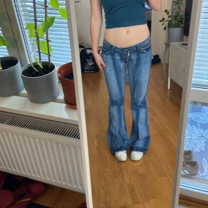  lågmidjade bootcut jeans! - As snygga lowwaisted utsvängda jeans som är något randiga i tyget! I mycket bra skick, är bara lite lite nertrampade där bak. Annars inga fläckar eller hål. Size L. Skulle aäga att dom är 36or i storlek. Midjemått 80cm runt om. Innerbenslängd 81cm! 