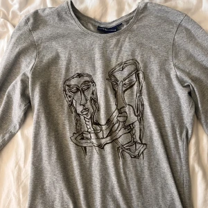 Tröja med tryck - Långärmad grå topp med abstrakta ansikten som tryck. Bra skick. Kom privat för fler bilder.💕