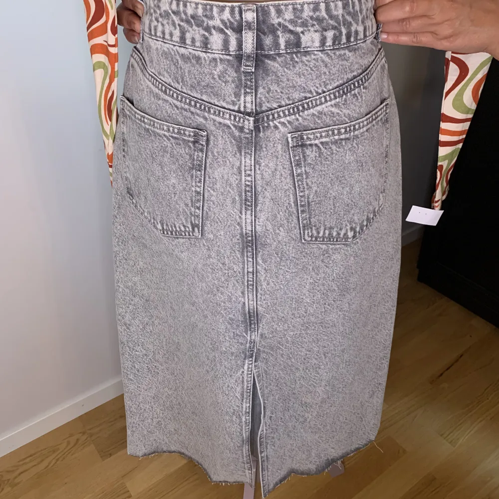 Säljer en helt oanvänd jeans kjol som är grå från MANGO i storlek M. . Kjolar.