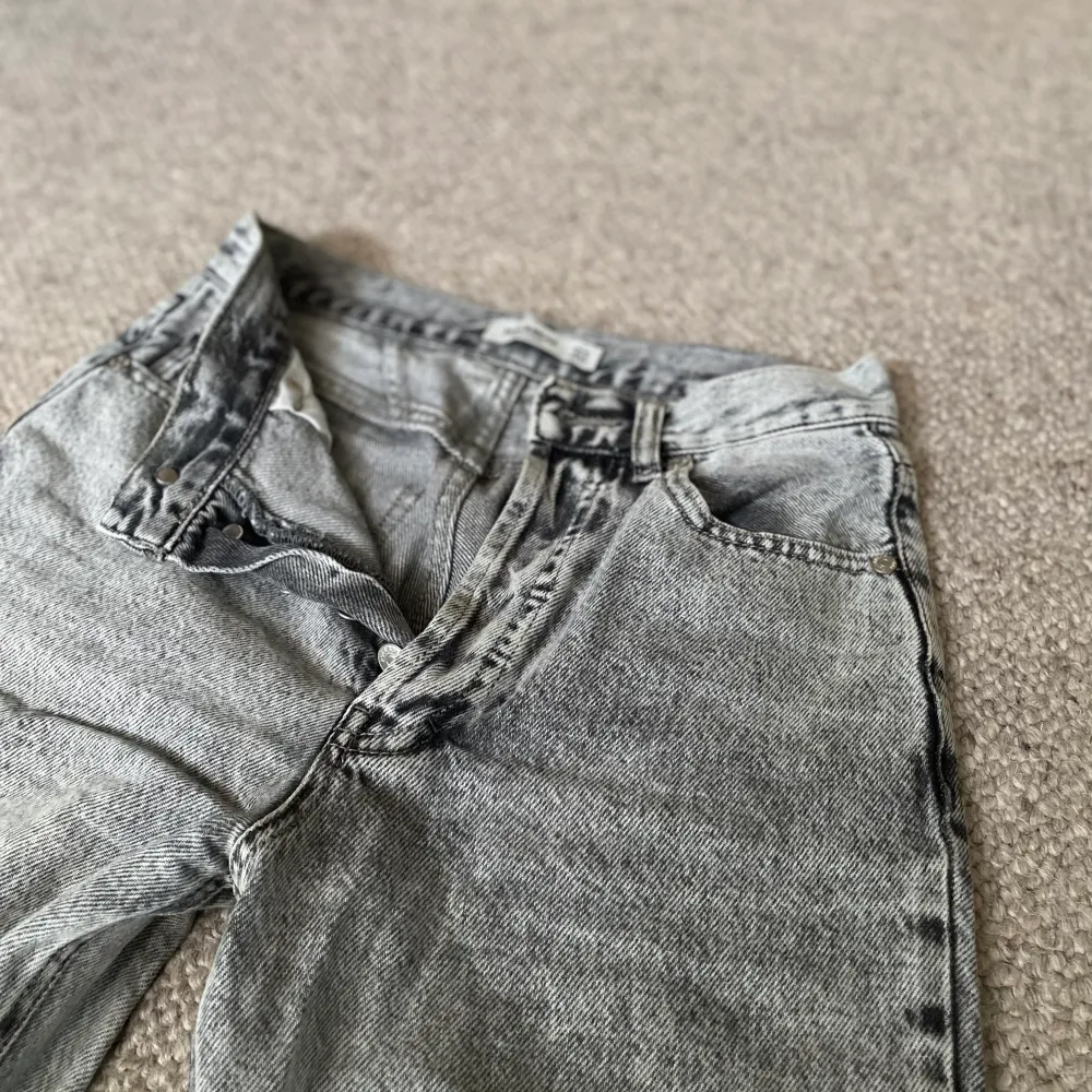 Fina gråa jeans från Pullbear som har använts ca 2 år. Ingert slitage men säljer då det inte riktigt är min stil längre💓vida i benen och i storlek 34💞skriv för fler frågor💞. Jeans & Byxor.