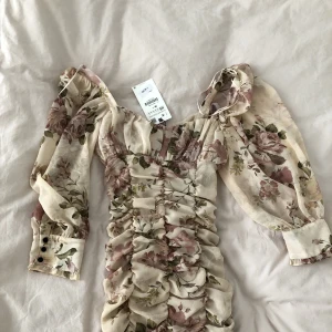 Blommig klänning Zara - Oanvänd blommig rynkad klänning från Zara.  
