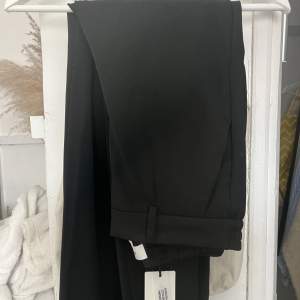 Helt nya svarta kostymbyxor som beställdes från nelly med stretch i ryggen. Tyvärr för långa för mig som är 160 och jag är för lat för att sy upp. Passar därmed någon som är runt 170. Köptes för 499kr men kan tänka mig sälja för 400!