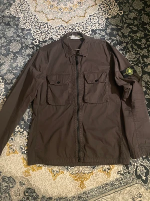 Stone island overshirt herr - Stone island jacka för herr. Passar för båda M och L. Den är knappt använd då den inte riktigt är min stil. Jag har bild på kvittot och ytligare bilder på jackan. Skriv bara till mig så löser vi det.