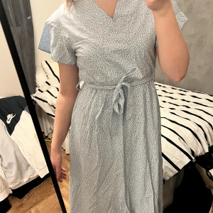 Blommig långklänning - Säljer denna fina blommiga klänningen som jag köpte på Missäy i Göteborg förra sommaren! Oanvänd. Har sytt igen urringningen då den var väldigt stor på mig men borde gå att sprätta upp om det önskas🥰 Den är Onesize då den har resår i midjan under bandet!