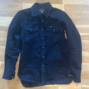 Ironheart selvedge denim shirt 14oz - IHSH-295-BB  Iron Heart's western cut shirt made from a 14oz black warp/black weft selvedge denim. The warp is black sulphur rope dyed, the weft is black sulphur dipped. Constructed with black tonal stitching. Will fade to grey.  Washed and slightly worn.