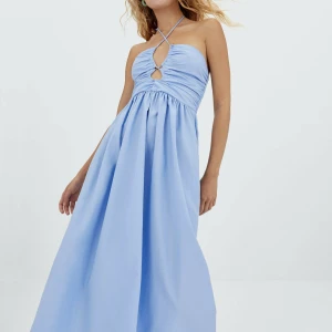 Lång klänning - OANVÄND!! Ljusblå långklänning som man kan knyta som på bilden eller som en bandeu! 