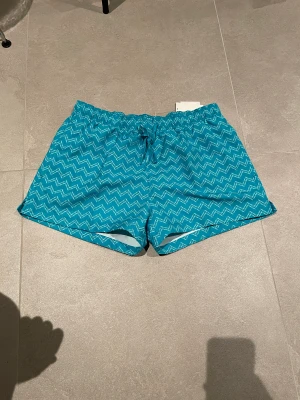 Badbyxor Calvin Klein L - Helt ny badbyxor i kortare model den Calvin Klein. Midjemått ca 42 cm (x2) och mått på benöppning är ca 34 cm. Är resor i midjan så storleken är givetvis flexibel. Storlek Large. Nypris 749 kr.