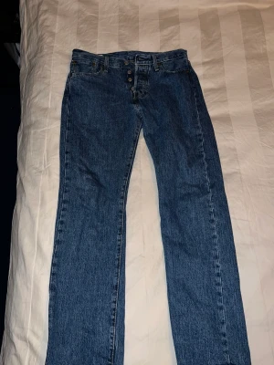 Levi’s 501 - Ett par klassiska mörkblåa Levi’s 501 i nyskick, helt felfria. Köpta på NK för 1195 kr. Skriv vid fler frågor, priset kan diskuteras