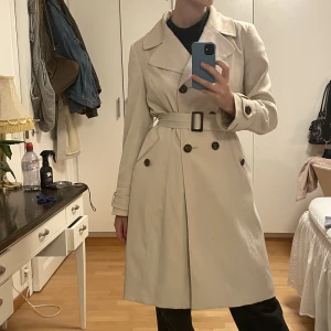 trenchcoat  - beige trenchcoat! jag är S som referens, går till knäna och jag är 173. Några små fläckar som knappt syns