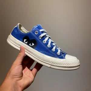 CDG Converse  - CDG Converse, jag säljer min riktigt schyssta marinblå CDG Converse p.g.a att jag har växt ur dom. Skorna är sparsamt använda och i riktigt bra skick. Jag köpte dom på NK, nypris 1495 kr. Dom är storlek 39 och 24.5 cm långa.  