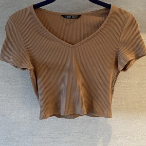 T shirt  - Brukar t shirt med v ringning. Längd på 18 cm från armhålan och midje mått på 32 cm. 