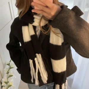 Halsduk  - Väldigt lång och mysig halsduk med svart vita ränder o lite tofsar på kortsidorna. Knappt använd!🩷