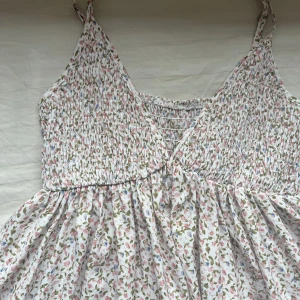 Blommig klänning  - En super söt blommig klänning som inte kommer till användning, sparsamt använd bra i skick. Hör av er vid intresse. Kramis 