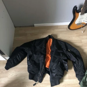 Bomber jacka  - En svart bomber jacka som sitter rätt så stort skulle säga att det är mellan l-xl men på längden på kroppen skulle den kunna va S-m😅😂