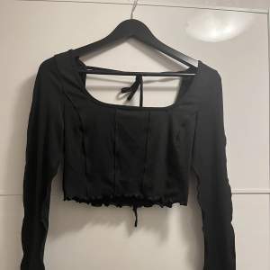 En svart tröja från Shein, den knyts på ryggen, ganska öppen rygg. Använts endast 1 gång. 