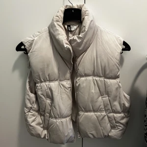 Beige väst  - Säljer en kortare modell av väst i färgen beige, använd enstaka gång så i väldigt bra skick! 